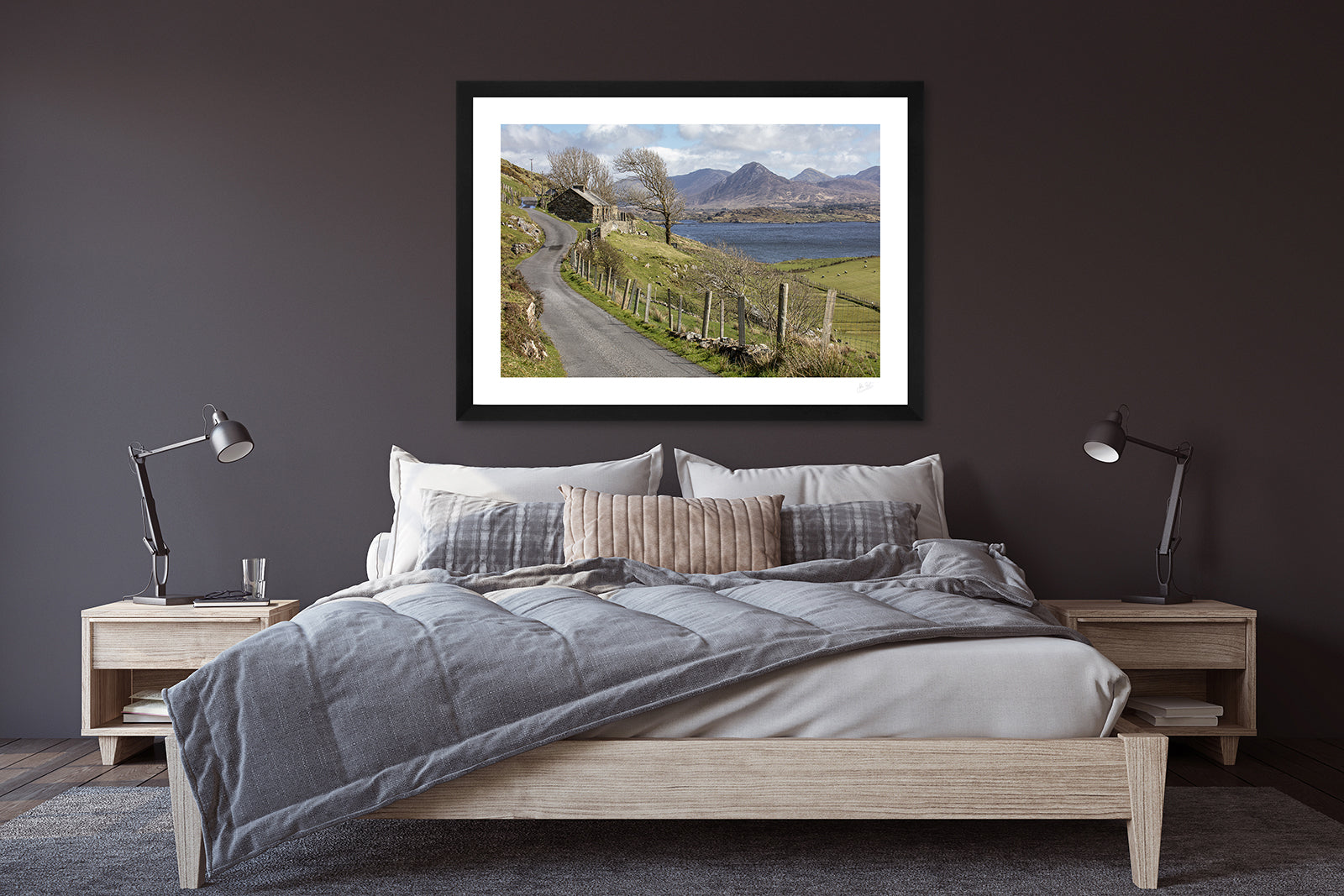 a framed fine art photographic print of Connemara from Derryinver on the Renvyle Peninsula with its rugged landscape, sea, inlets and islets, and the 12 Bens mountain range, hanging above a bed