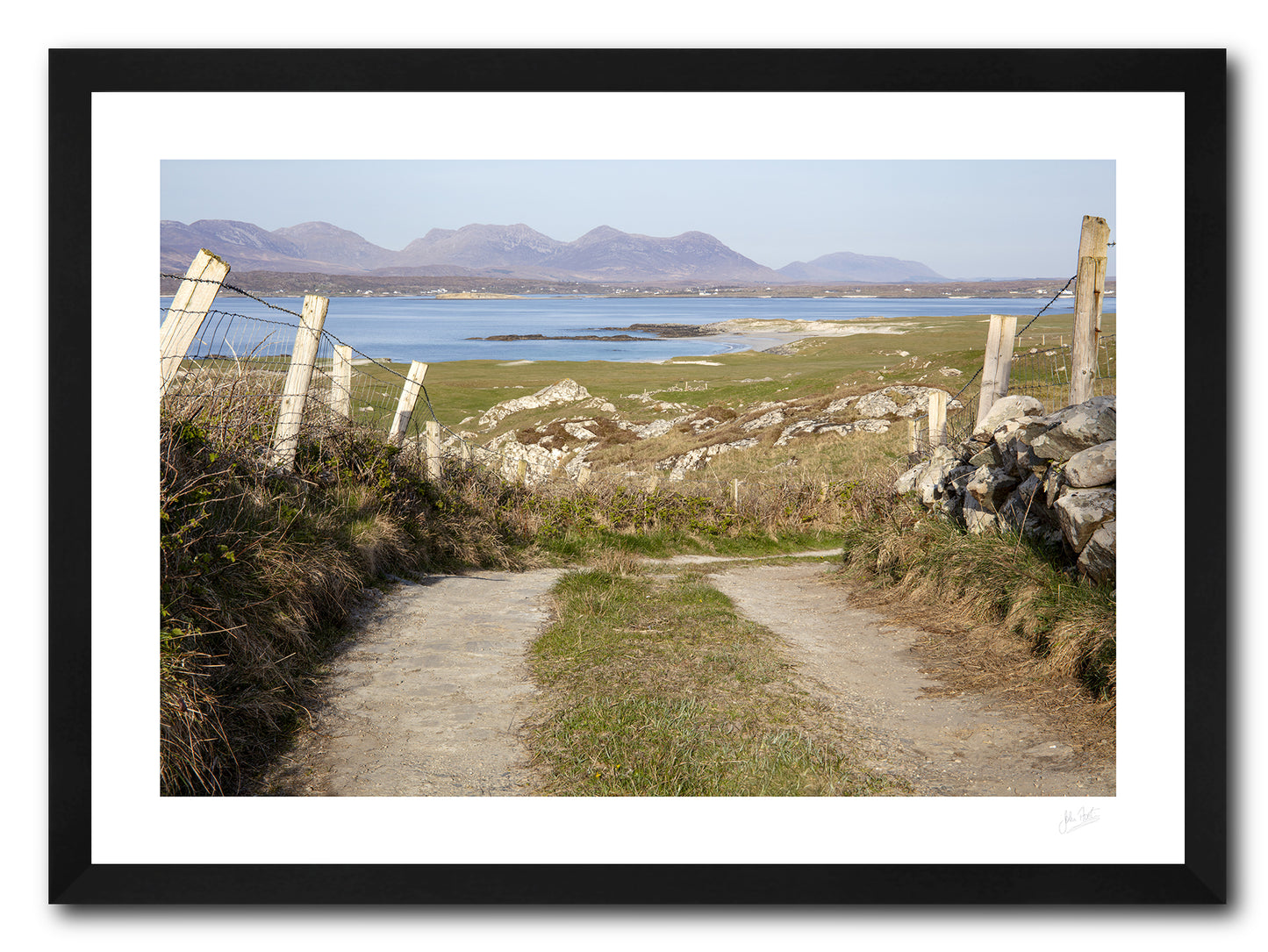 a framed fine art photograph of the view from a narrow country road in Mannin Beg, Connemara looking across Mannin Bay at the 12 Bens mountain range
