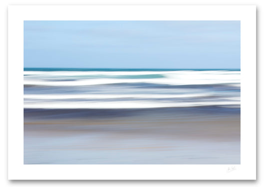 an unframed fine art photograph using intentional camera movement of white waves off Famara Beach, on the island of Lanzarote in the Canary Islands providing a lovely contrast to the blue sea and sky.