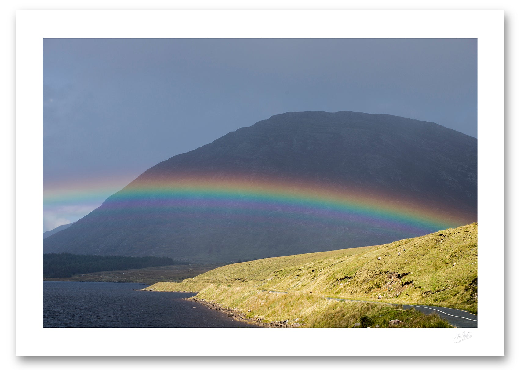 an unframed fine art photographic print of a rainbow stradling Lough Inagh, Connemara as the rain shower moves away toward Letterbreckaun Mountain, available to buy online