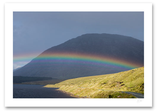 an unframed fine art photographic print of a rainbow stradling Lough Inagh, Connemara as the rain shower moves away toward Letterbreckaun Mountain, available to buy online