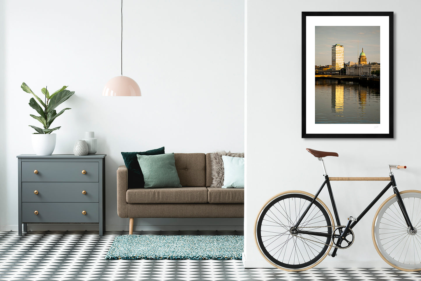 a framed fine art photographic print of Dublin's Custom House building along with Liberty Hall and the Spire reflecting the golden light of sunrise, hanging on a living room wall