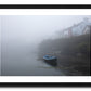 a framed fine art photograph of a rowing boat moored in Roundstone Harbour, Connemara in dense fog with only a few of the towns buildings visible