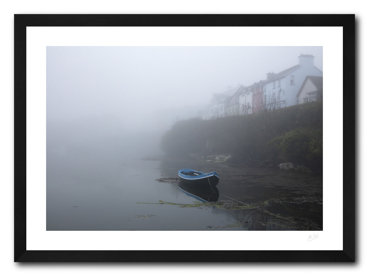 a framed fine art photograph of a rowing boat moored in Roundstone Harbour, Connemara in dense fog with only a few of the towns buildings visible