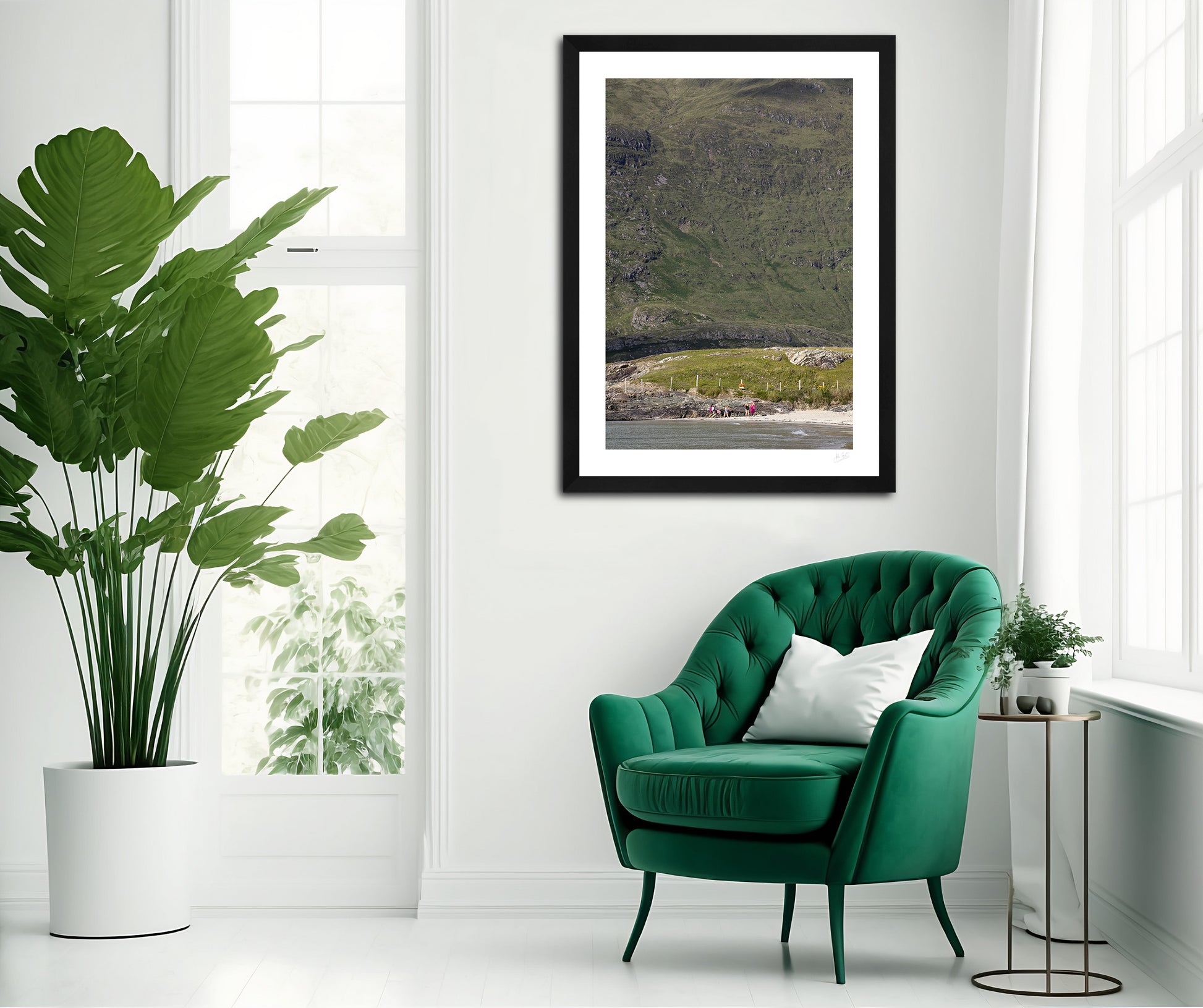 a framed fine art photogrphic print of friends catching up on a lovely summer afternoon on Glassilaun Beach, Connemara, Ireland with the large Mweelrea mountain as the background hanging on  white wall above a green chair 