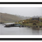 a framed fine art photograph of a fishing hut and row boat mooring on the Owenmore River on a rainy day with a few grazing sheep