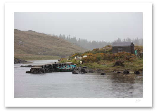 a fine art photograph of a fishing hut and row boat mooring on the Owenmore River on a rainy day with a few grazing sheep