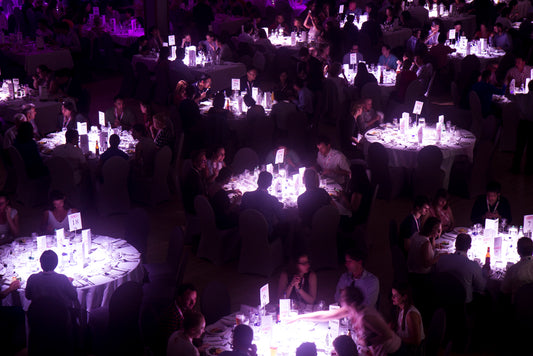 highlighted round tables and guests in a darkened dining room at the IHMC gala dinner