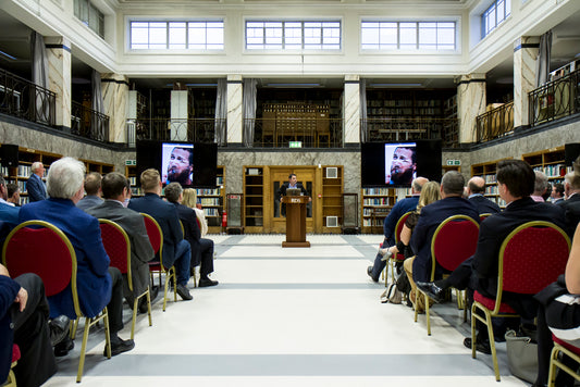 Inside the RDS members library where a man is making a presentation to an assembled audience