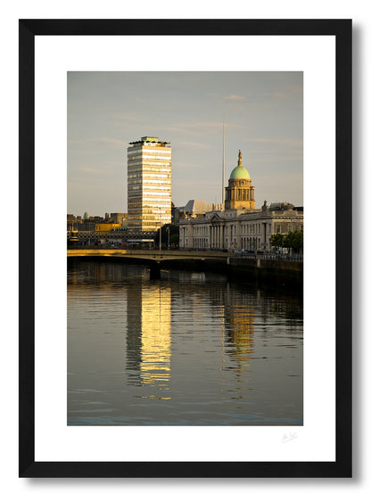 a framed fine art photographic print of Dublin's Custom House building along with Liberty Hall and the Spire reflecting the golden light of sunrise, available to buy online