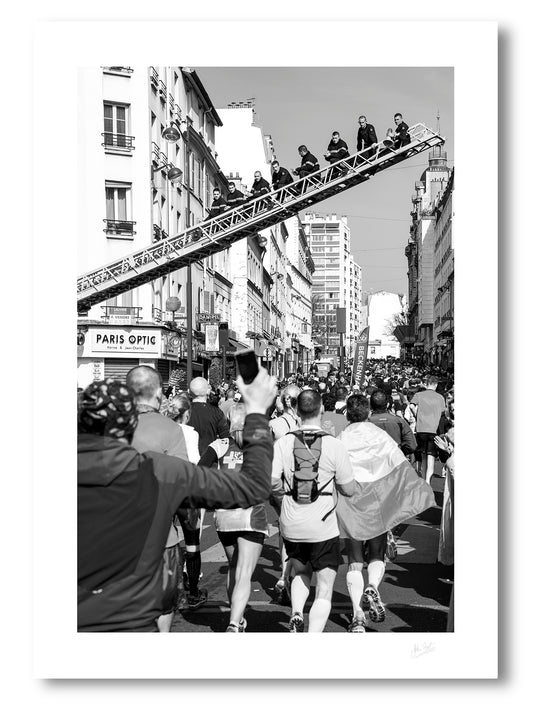 unframed fine art print of firemen sitting on a ladder above the runners in the Paris marathon