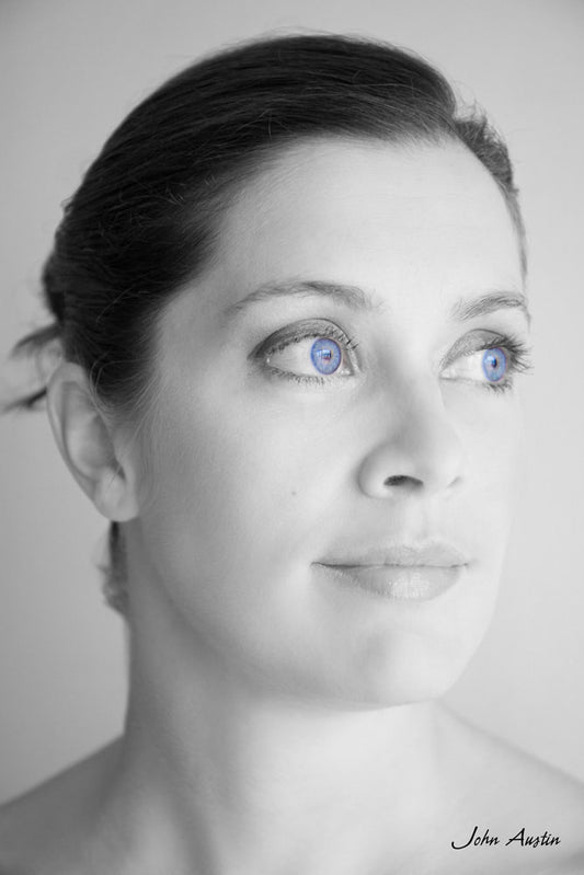 A black and white headshot portrait of Cliodhna with blue coloured eyes