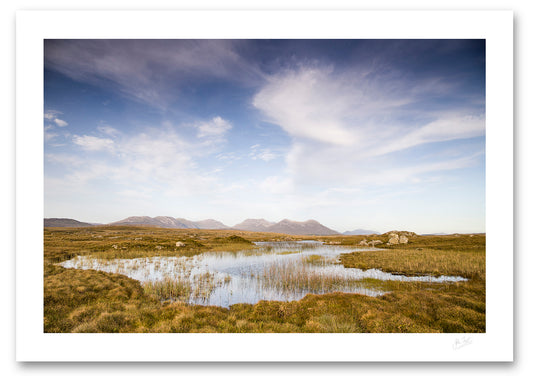 print of the spectacular Bog Road in Connemara on a beautiful Autumn evening as the sun blankets the peatland in an inviting amber glow below a vast calm blue sky