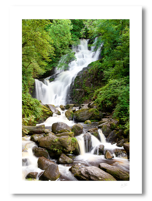 unframed fine art print of Torc Waterfall in Killarney with rock in the foreground and surrounded by green trees