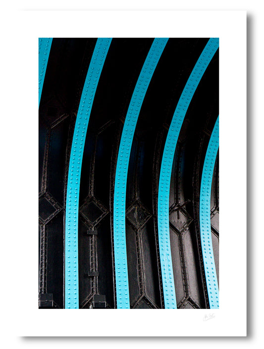 unframed fine art print of one of the arches of Tower Bridge in London with black painted iron and light blue curved struts